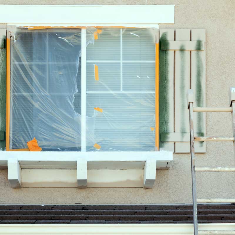 Nevada fix‑and‑flip renovation – window taped for painting and ladder outside