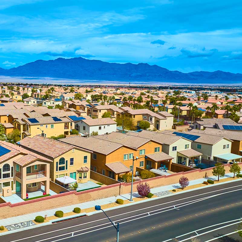 Suburban homes along a wide road with blue skies and desert mountains – top Nevada hard money lenders by rate