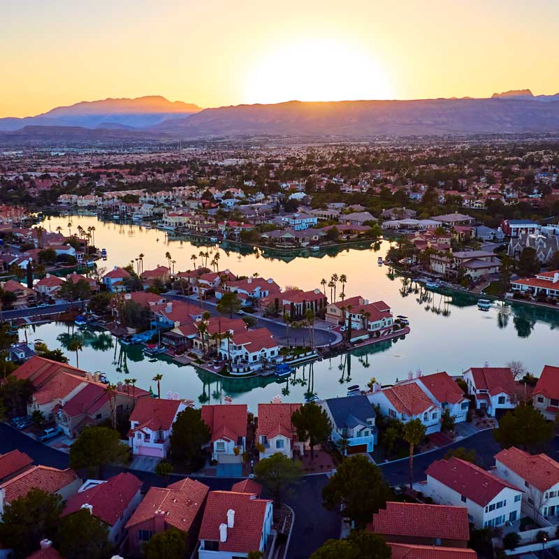 Sunset view of Lake Las Vegas with red‑roofed houses and mountains – illustrating fastest Nevada cash purchase and loan closing times