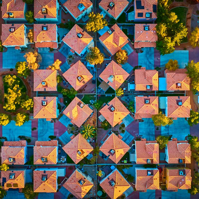 Symmetrical aerial view of Reno neighborhood with fall trees and teal roofs – Reno real estate market 2025